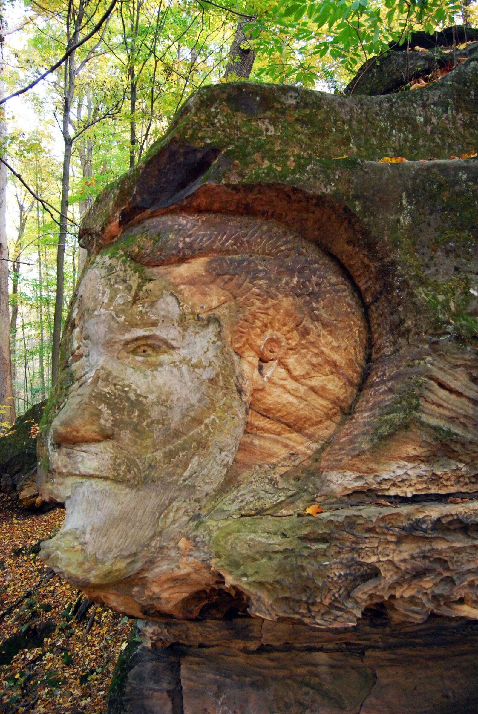 Bas-relief carvings on the sandstone cliff face at Worden's Ledges, Hinckley Reservation. Human faces, dates, religious symbols, and a schooner are chiseled into the rock.