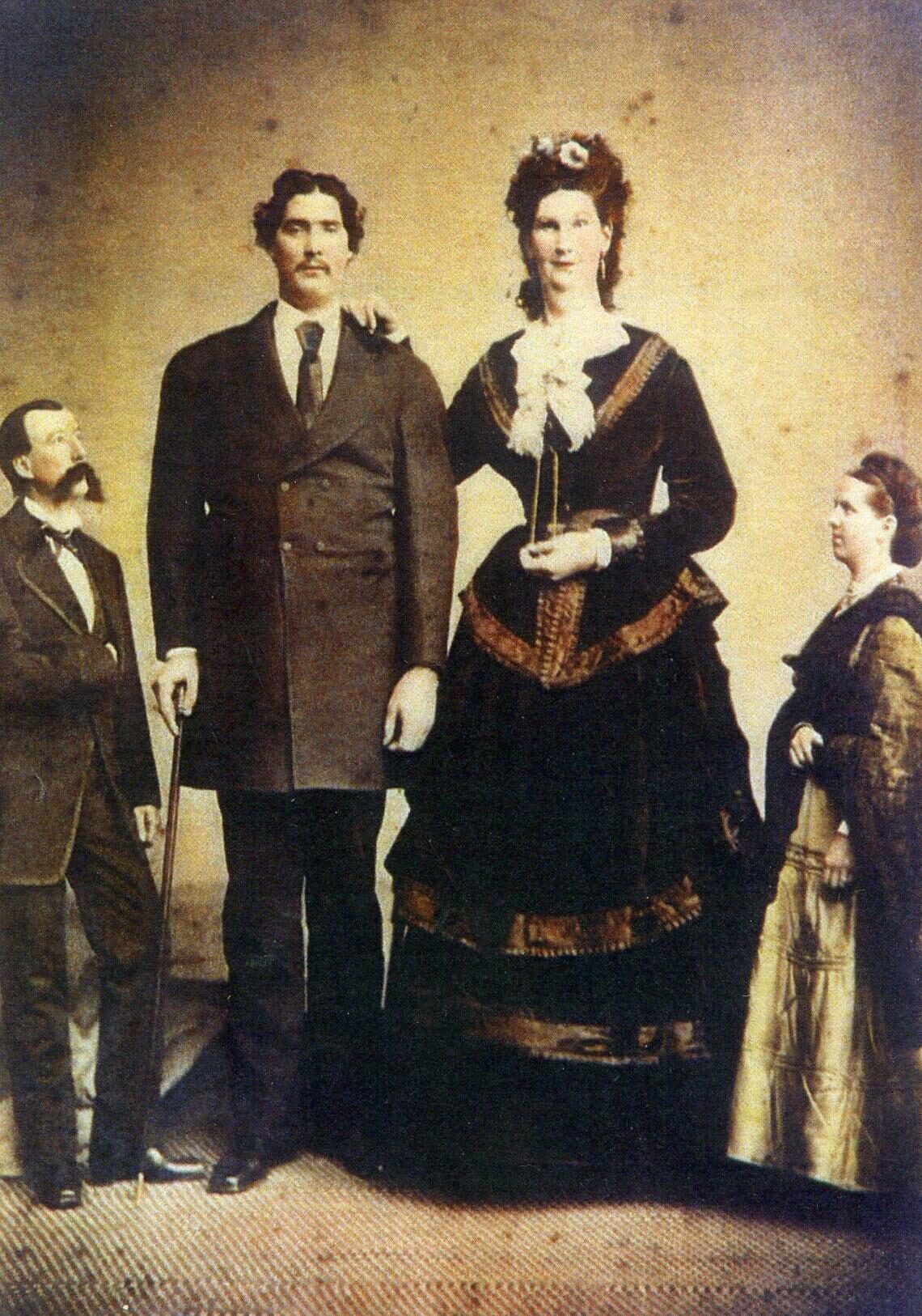 Full-length studio portrait of Captain Martin Van Buren Bates and Anna Haining Swan Bates standing together as a couple, photographed around the time of their 1871 wedding in London.
