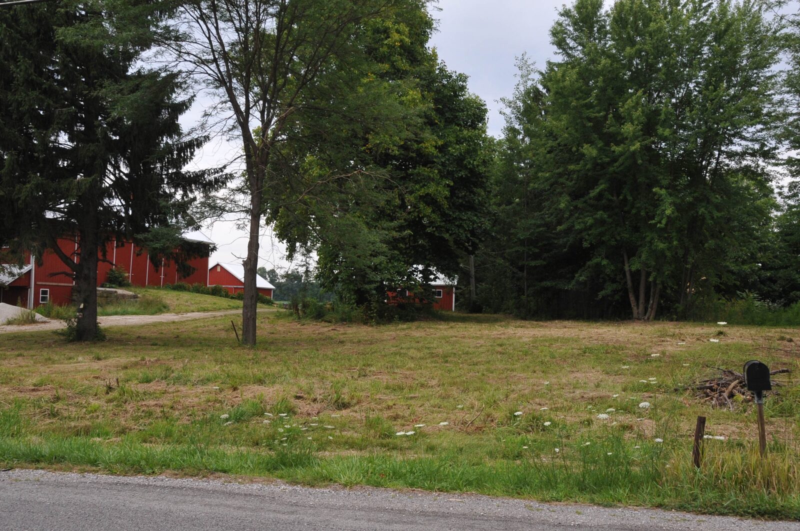 Landscape view of the Paleo Crossing site in Sharon Township, showing open farmland with a nearby farm building.