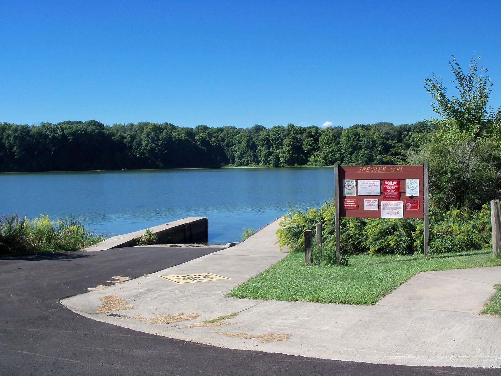 Boat launch at Spencer Lake Wildlife Area in Spencer Township, showing a wetland lake surrounded by trees.