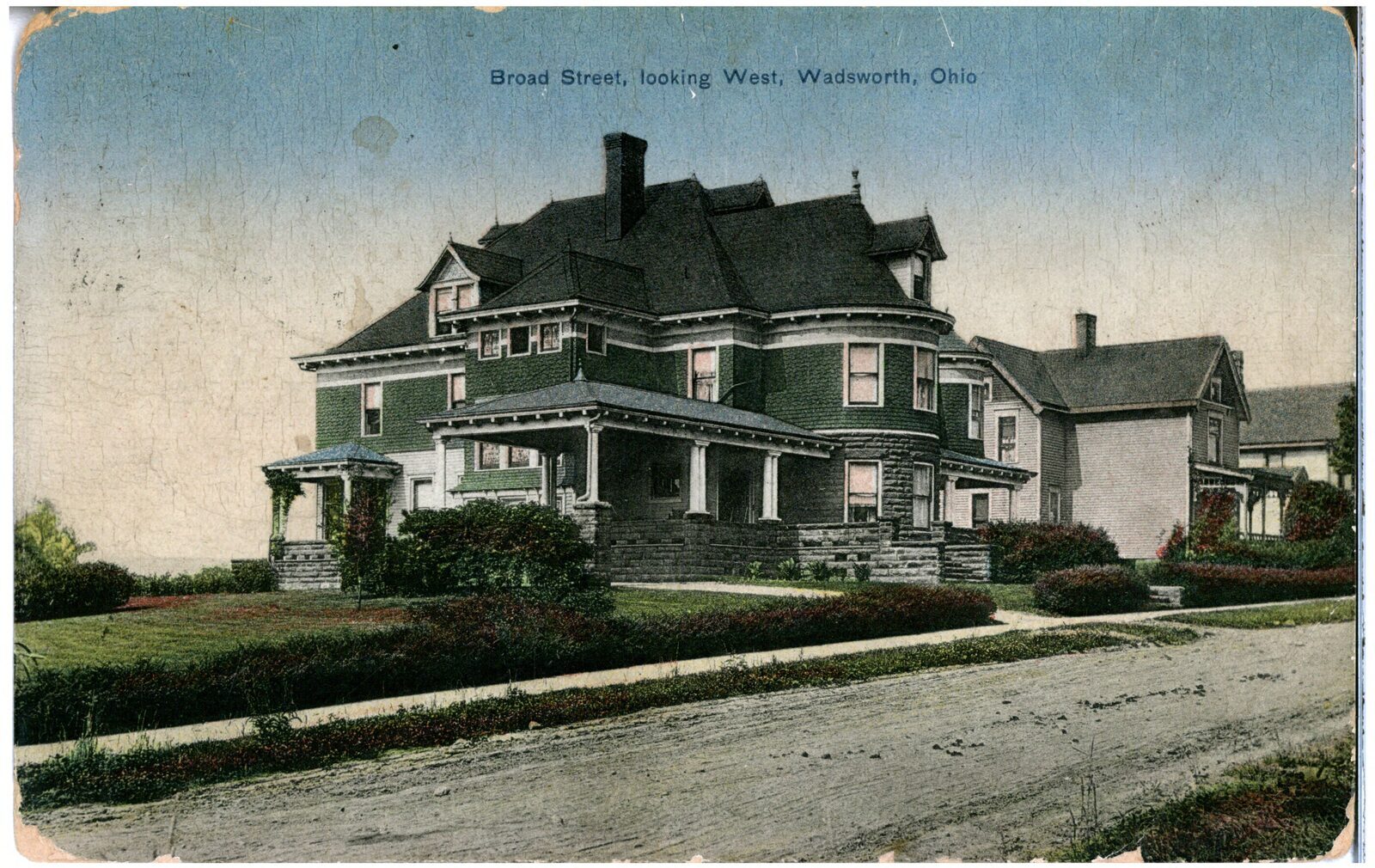 Broad Street looking west in Wadsworth, Ohio, 1911. Two-story brick storefronts line an unpaved street with early automobiles and utility poles.