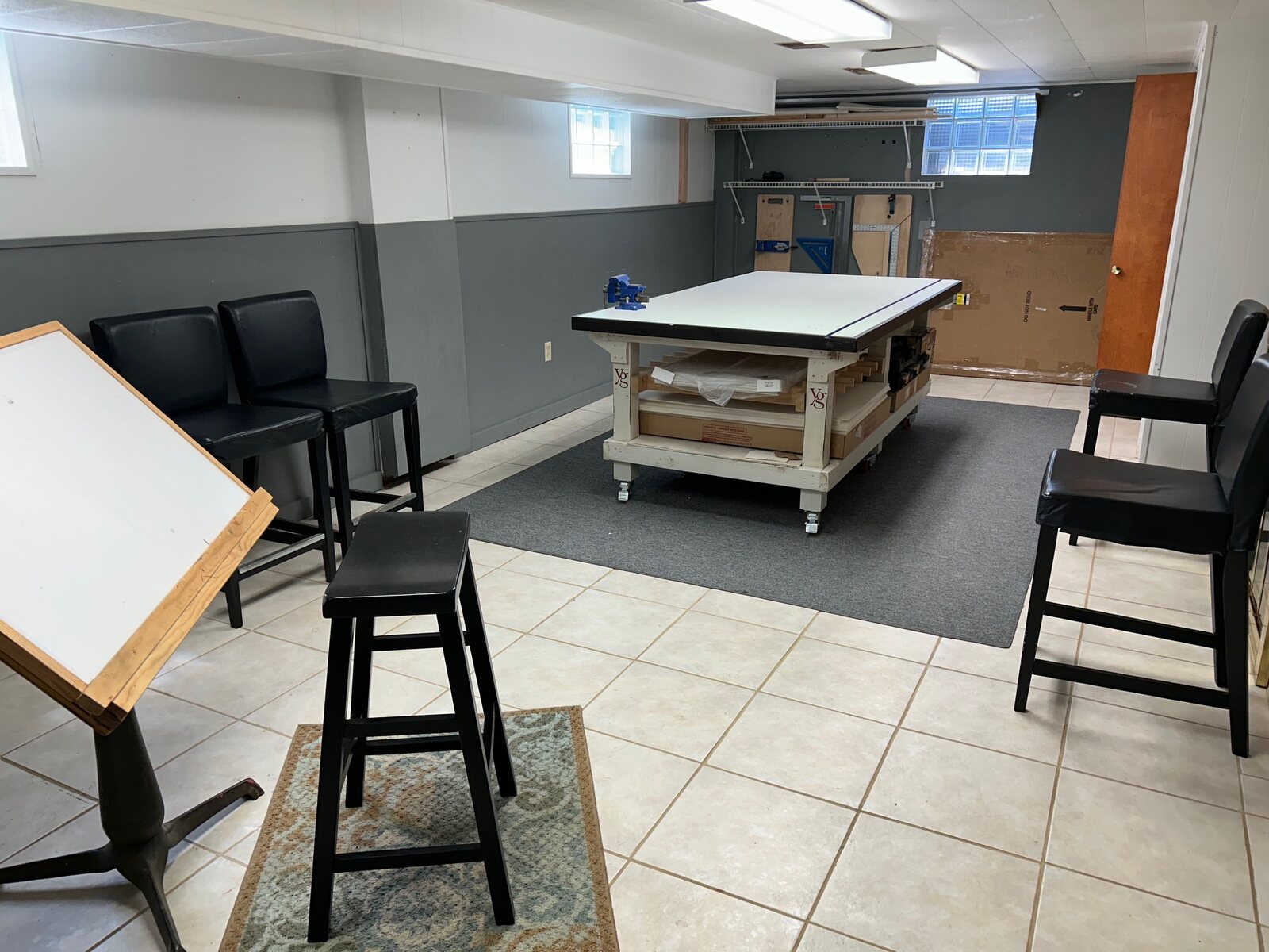 Finished lower level used as an art and craft room, drafting table and work table