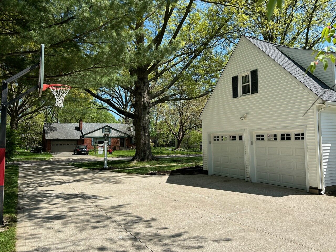 The driveway, basketball hoop, and the detached two-car garage