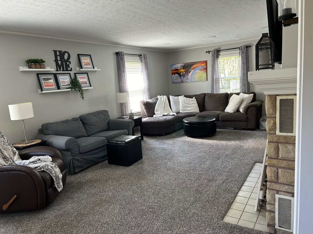 Living room with a gray sectional and the stone fireplace