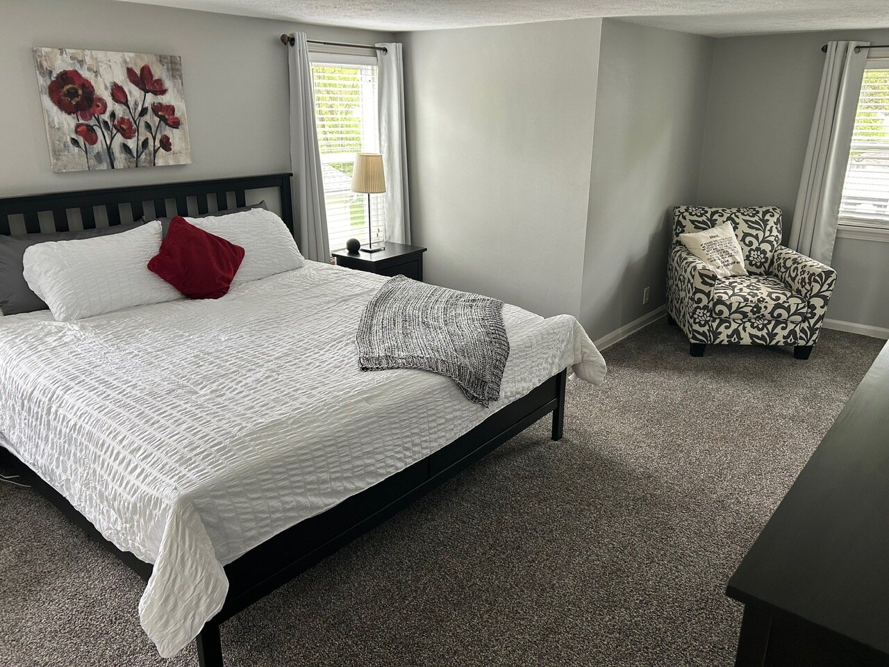 Primary bedroom with two windows and a reading chair