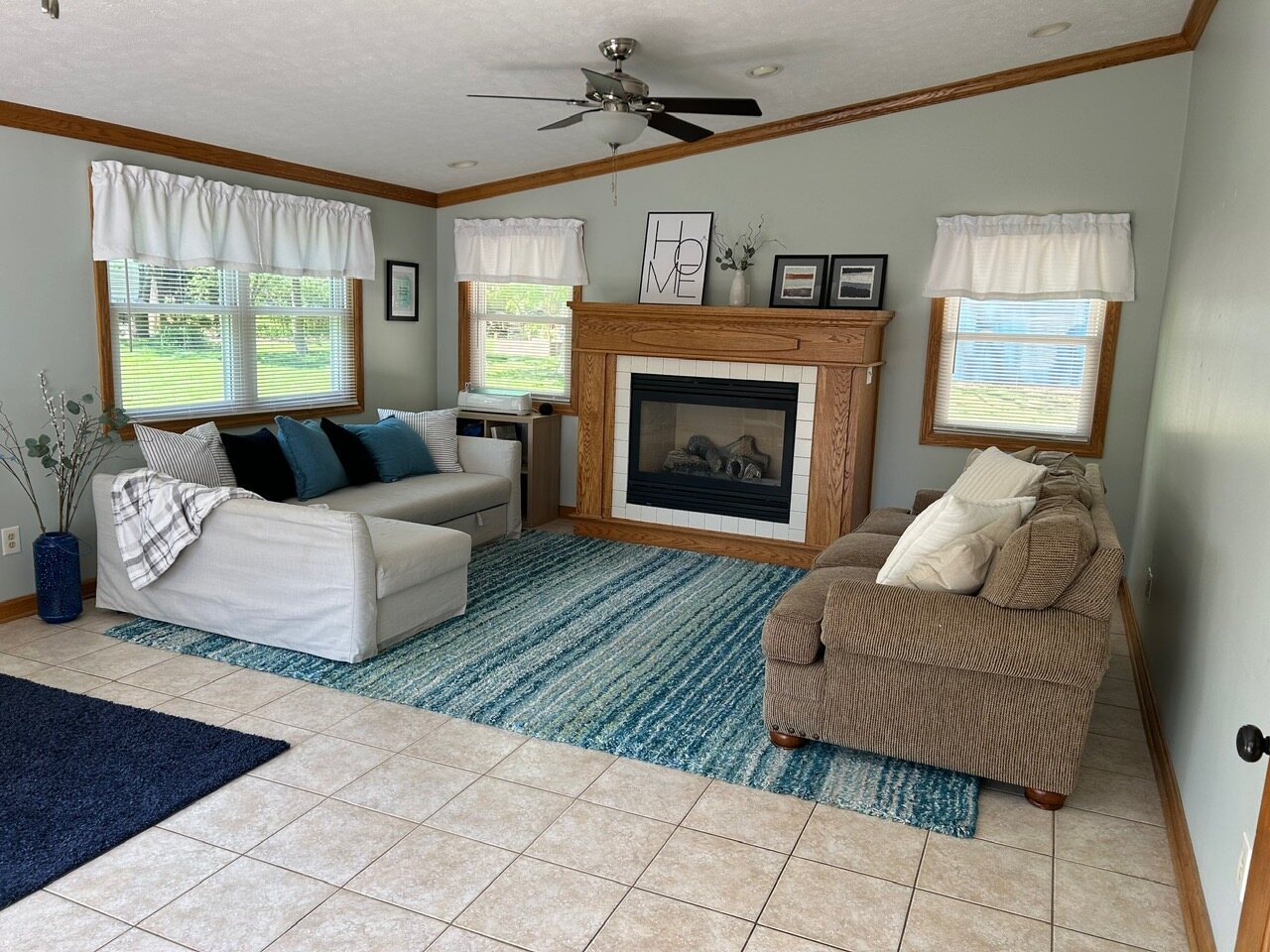 Sunroom with its own fireplace, sectional, and windows on three sides